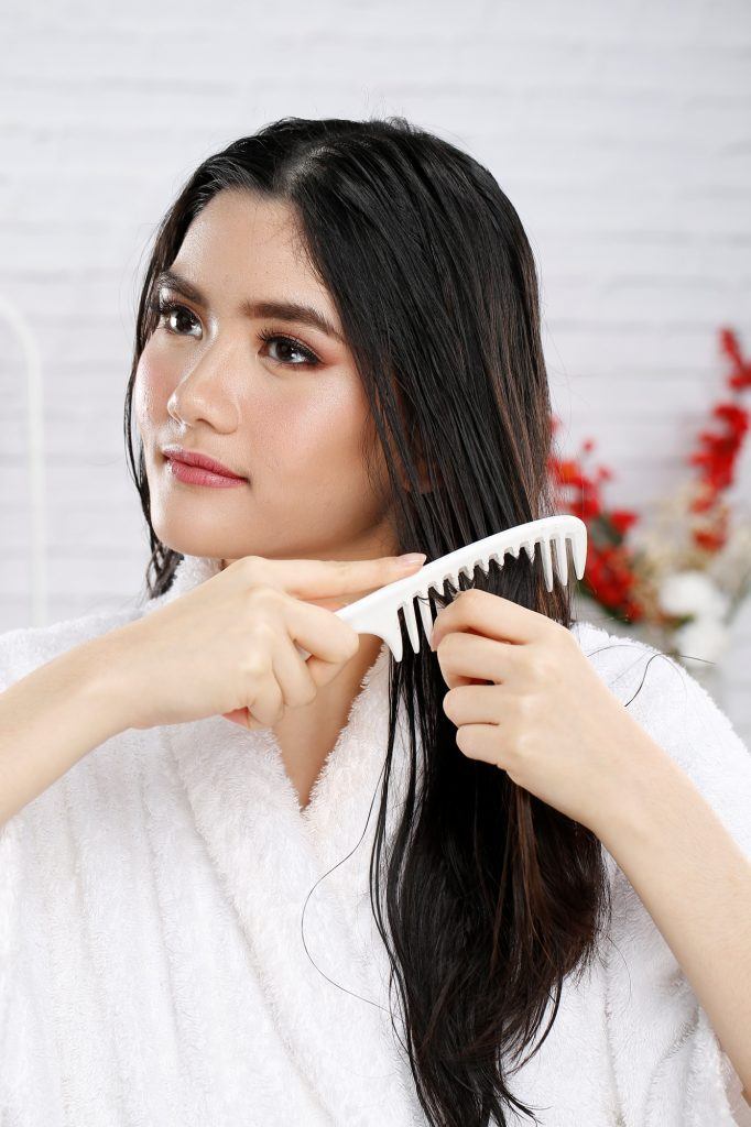 Menyisir rambut dengan sisir bergigi jarang