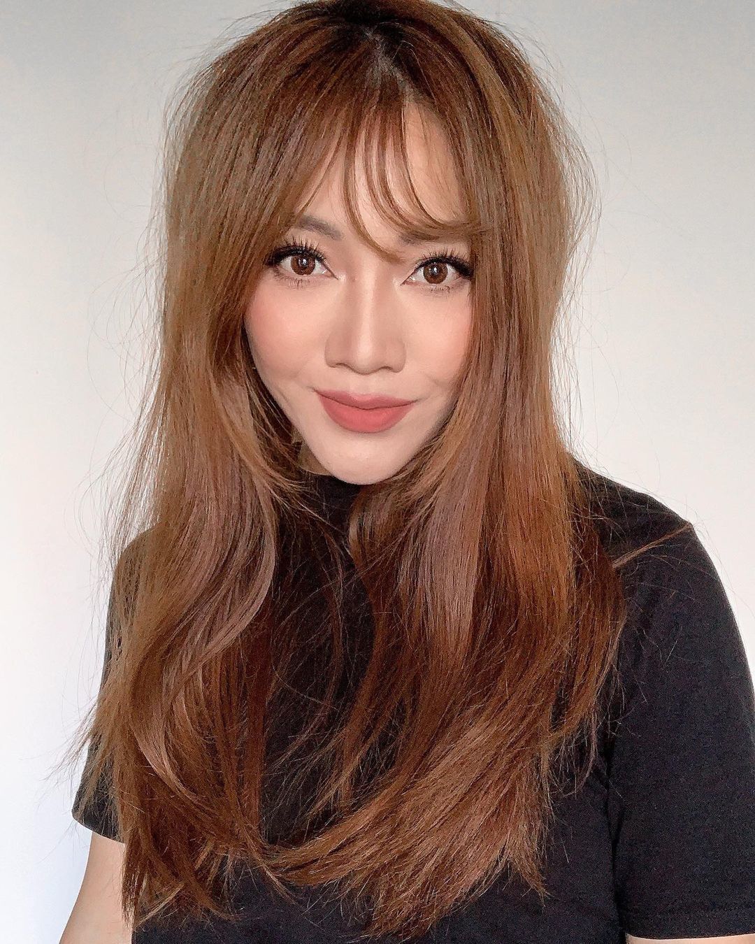 wanita asia dengan poni wispy korea dan rambut panjang warna cokelat