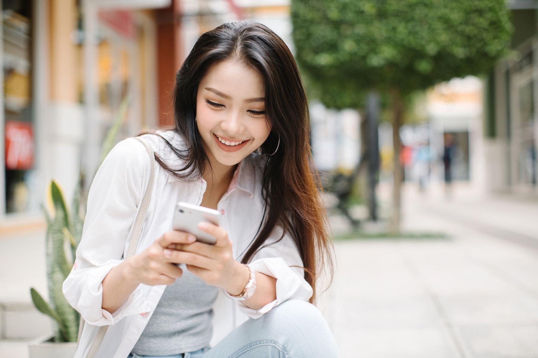 Wanita asia menggunakan handphone untuk browsing di aplikasi tinder