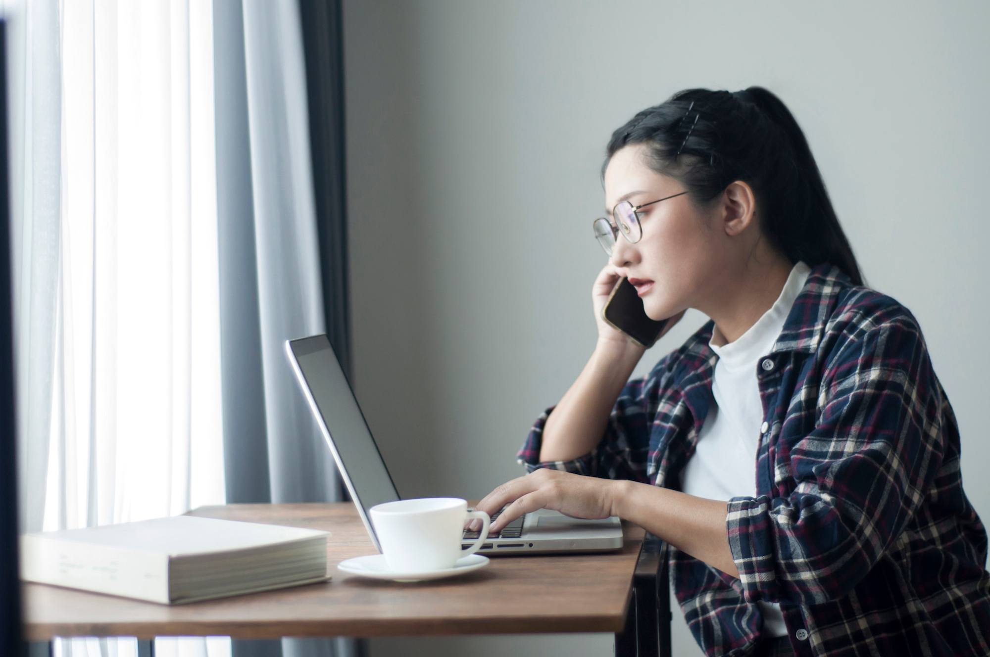 Wanita asia kerja di rumah menggunakan cardigan