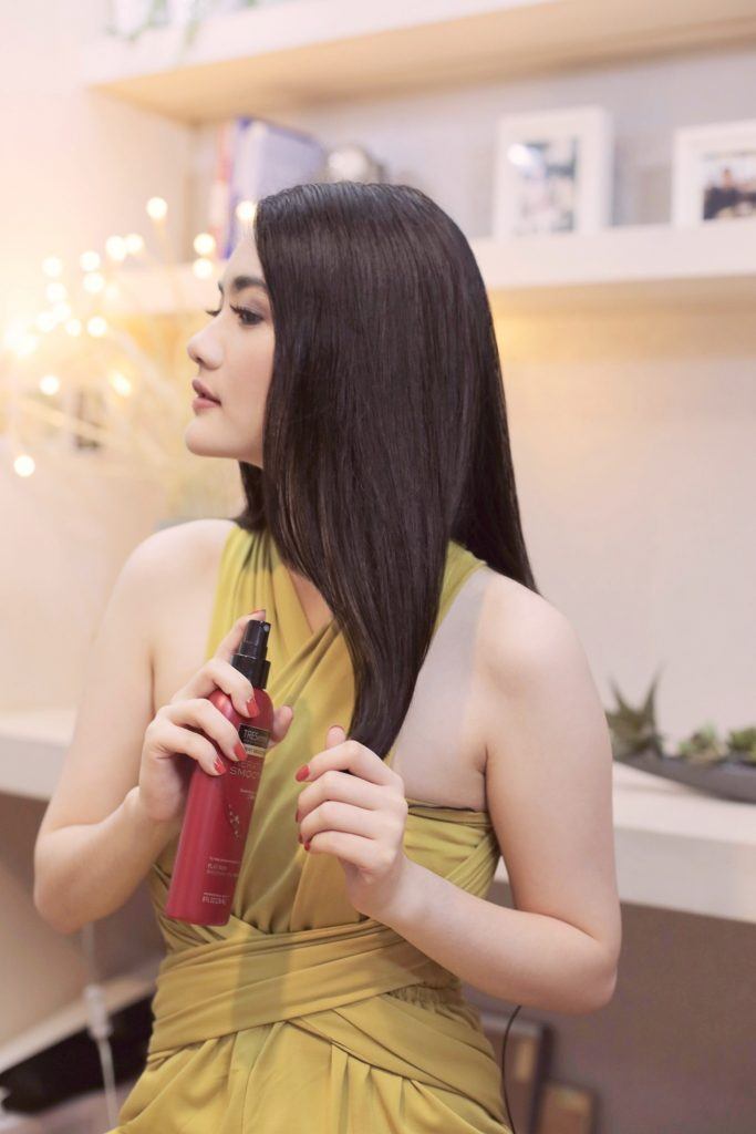 Wanita asia menyemprotkan spray rambut
