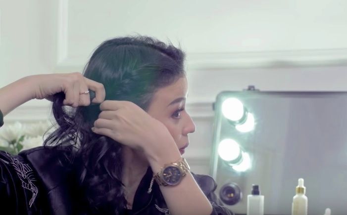 Kimberly Ryder dengan warna rambut hitam sedang membuat twist pada sisi rambut