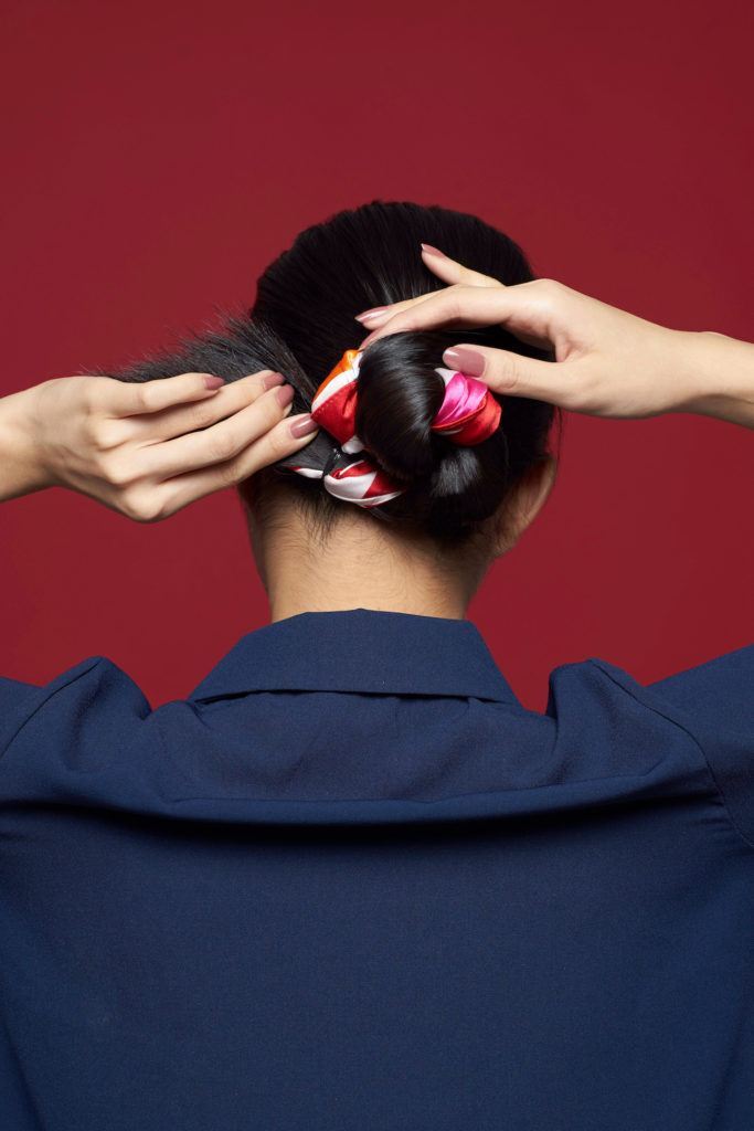 Wanita asia dengan rambut hitam membentuk sanggul kepang – cara menata scarf rambut.