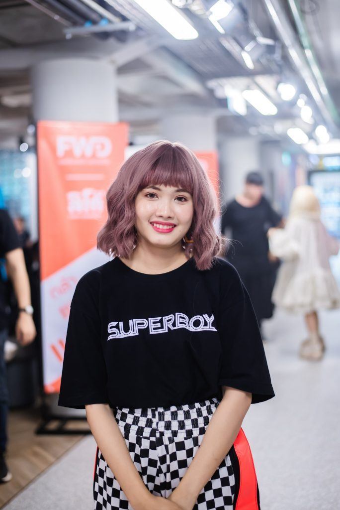 wanita asia dangan wajah bulat dengan rambut pendek sebahu bergelombang dan berwarna ungu pastel