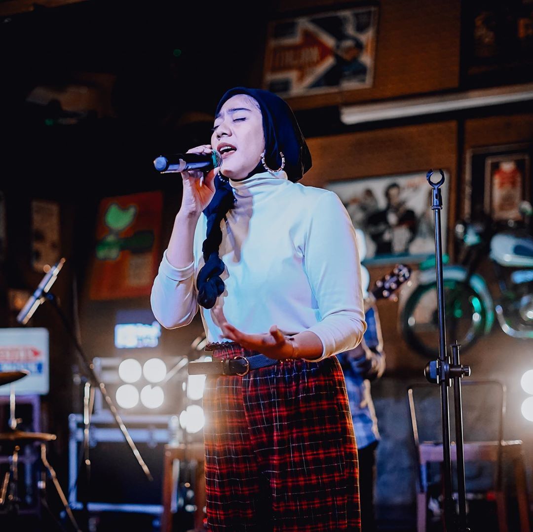 Tiwu Rayi hijabers sedang menyanyi di kafe.