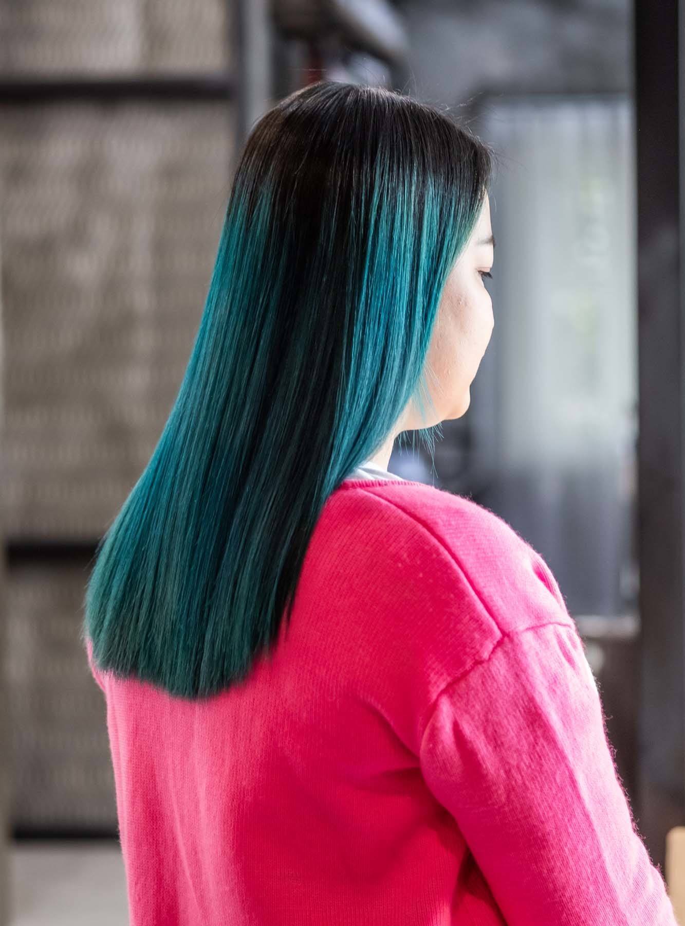 ผู้หญิงเอเชีย สวมเสื้อสีชมพู ผมสีเขียวน้ำทะเล