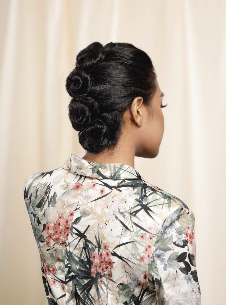 ผู้หญิงเอเชีย ไว้ผมยาวหยิก สีดำ รวบผมด้านหลังขดเป็นวง