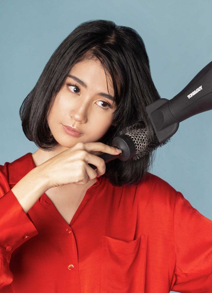 ผู้หญิงเอเชีย ผมประบ่า กำลังไดร์ผม