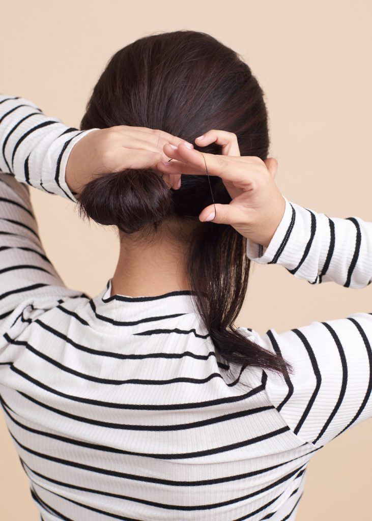 ผู้หญิงกำลังมัดผม