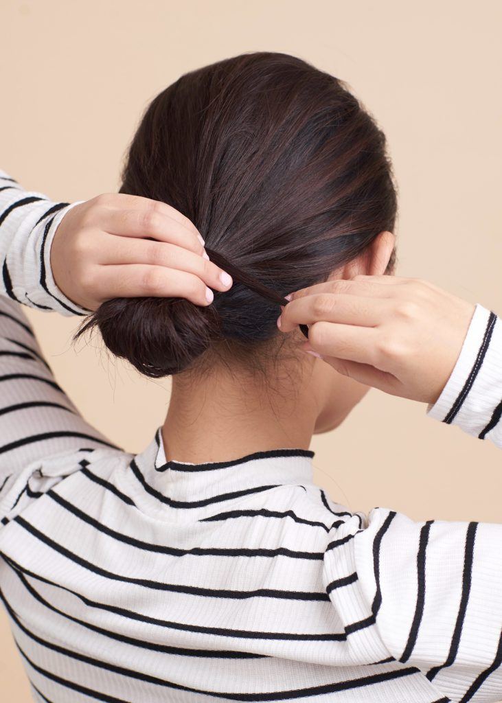 ผู้หญิงกำลังมัดผม