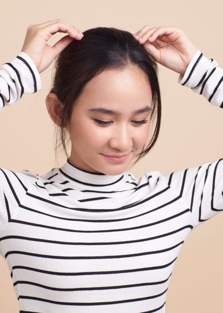ผู้หญิงกำลังดึงปอยผมลงมา