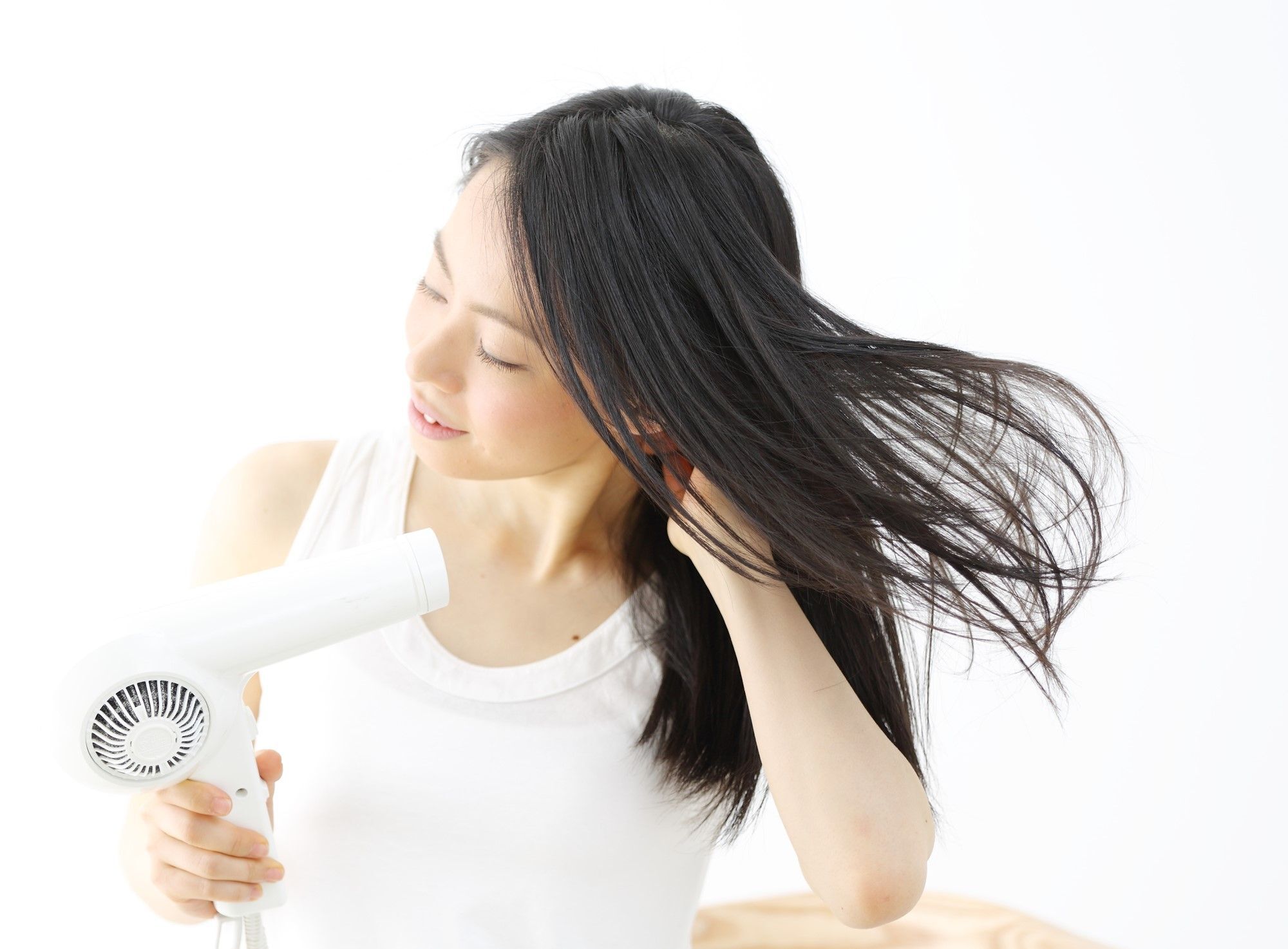 ผู้หญิงกำลังใช้ไดร์เป่าผม