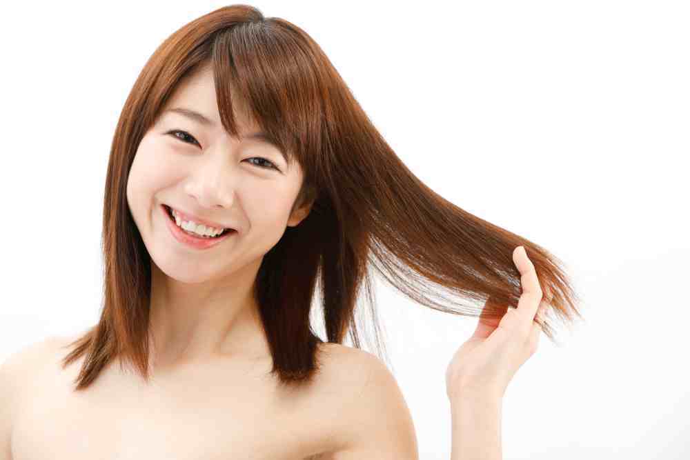 ผู้หญิงเอเชีย ผมยาวประบ่า กำลังจับผม ย้อมผมด้วยเฮนน่า