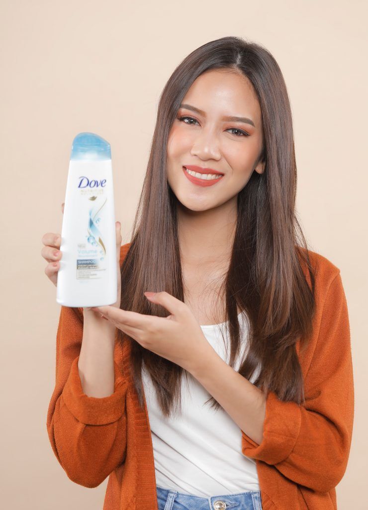 ผู้หญิงเอเชียผมยาวเสื้อส้ม ดัดผมลอนโดยใช้ โรลม้วนผม