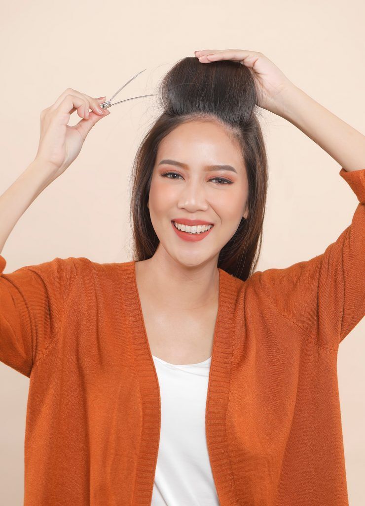 ผู้หญิงเอเชียผมยาวเสื้อส้ม ดัดผมลอนโดยใช้ โรลม้วนผม