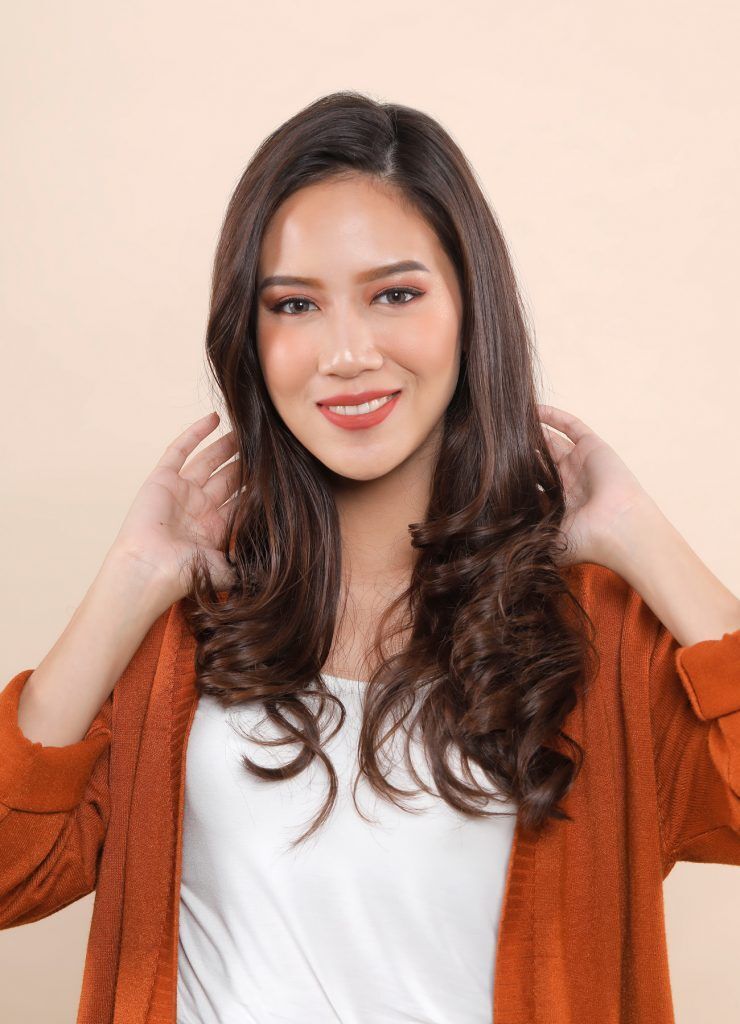 ผู้หญิงเอเชียผมยาวเสื้อส้ม ดัดผมลอนโดยใช้ โรลม้วนผม