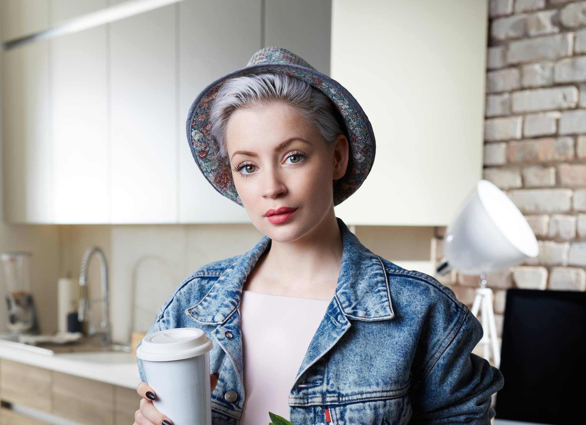 ผู้หญิงผมสั้นสีเทา ใส่เสื้อยีนส์ และหมวก