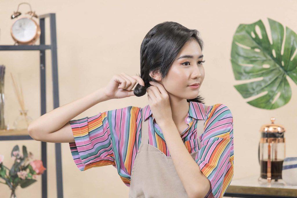 ผู้หญิงเอเชียผมสั้นสีดำ กำลังมัดผม