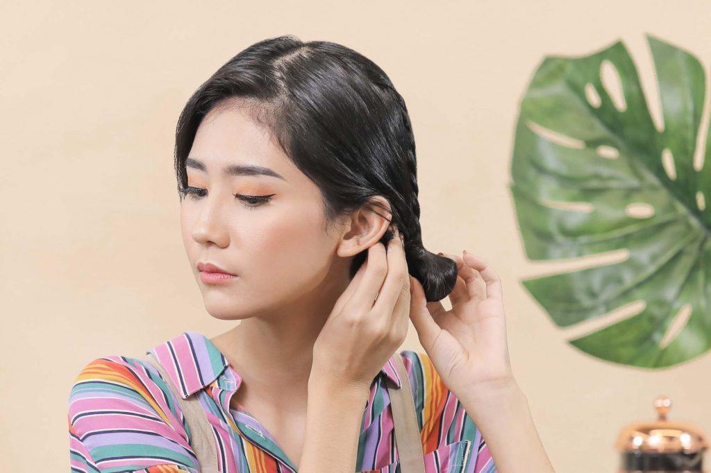 ผู้หญิงเอเชียผมสั้นสีดำ กำลังมัดผม