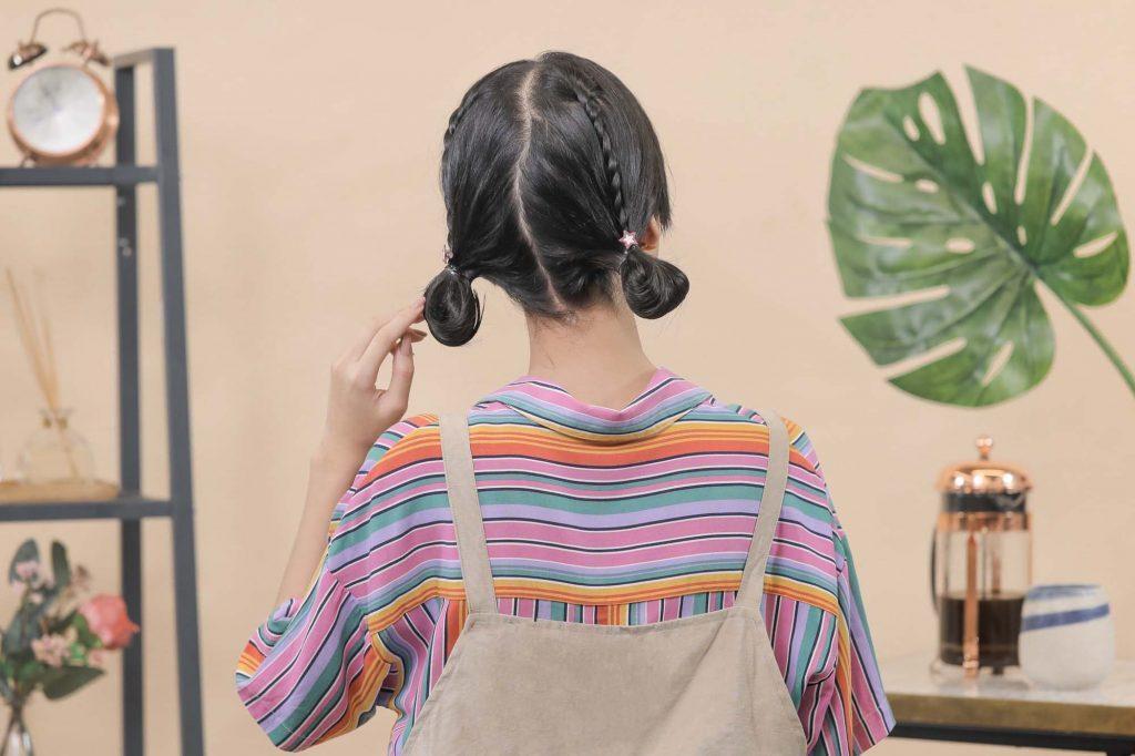 ผู้หญิงเอเชียผมสั้นสีดำ กำลังจับทรงผมด้านหลัง