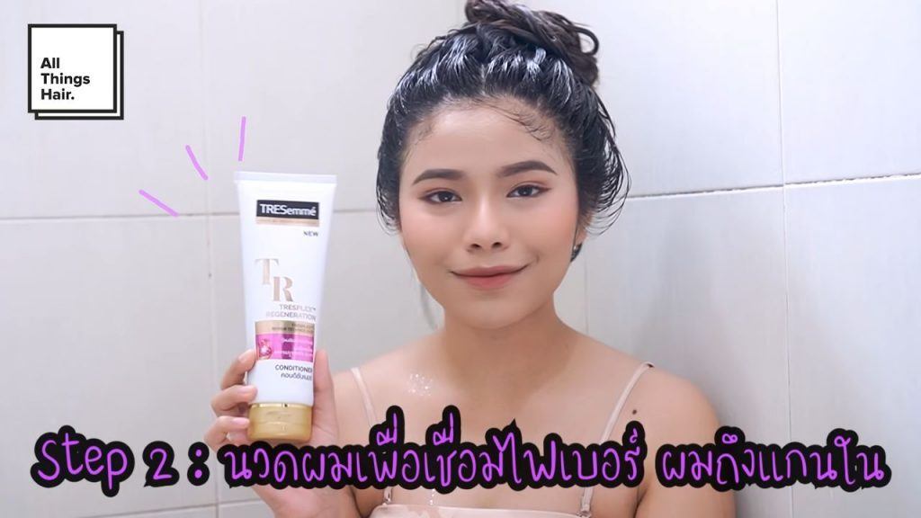 ผู้หญิงเอเชีย ผมดำยาว ถือครีมนวดผม กำลังสระผมและจะทำทรีทเม้นท์