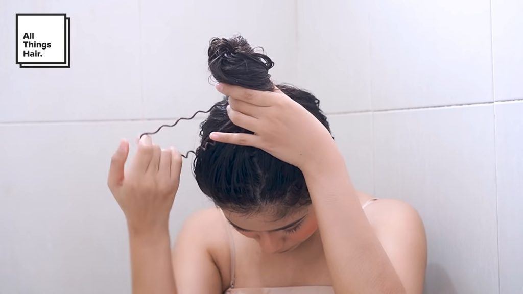 ผู้หญิงเอเชีย ผมดำยาว กำลังรวบและมัดผม