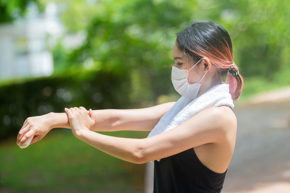 หญิงสาว เอเชีย ใส่เสื้อกล้าม ทาครีม ที่แขน