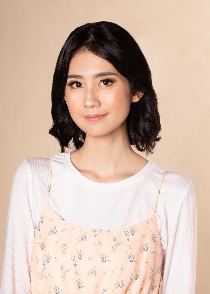 ผู้หญิงเอเชียผมสั้น ใส่เสื้อสีชมพูอ่อน