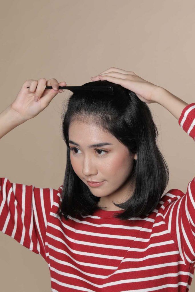 ผู้หญิงเอเชีย ผมสั้น กำลังรวบผม สาธิตวิธีทำ ทรวผมสั้น ถักเปีย