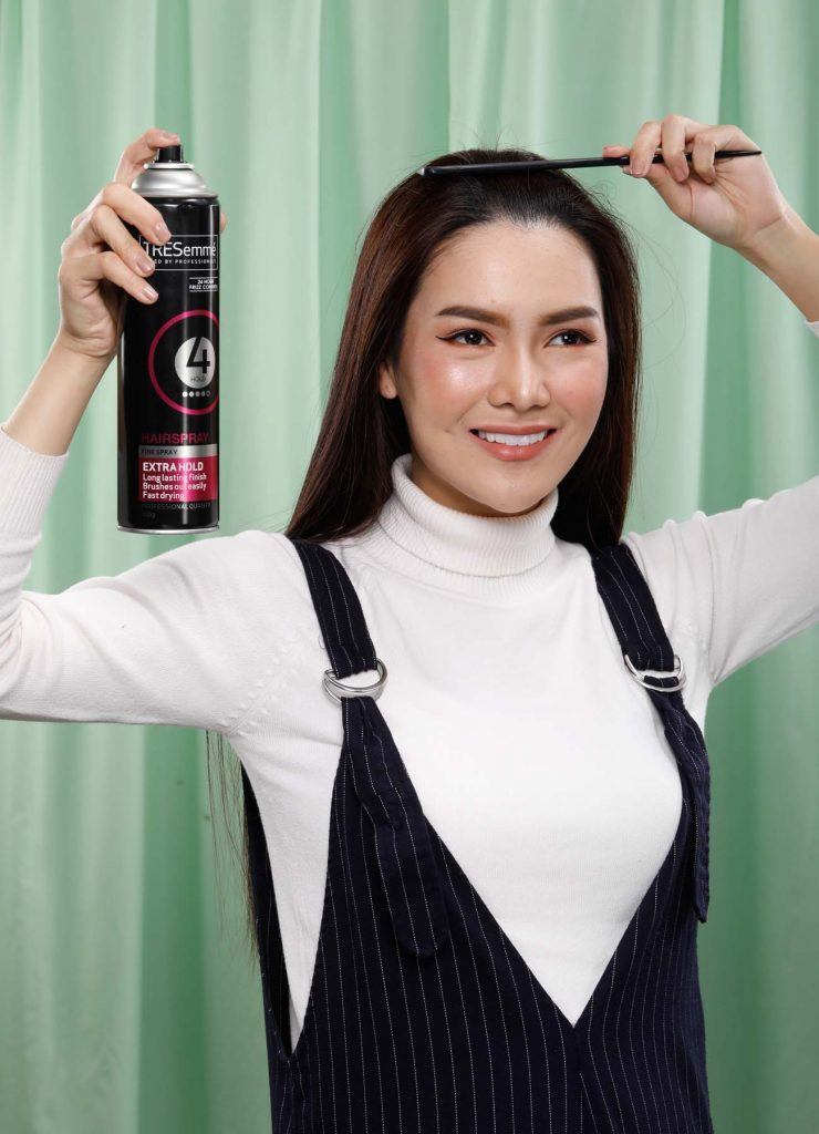 ผู้หญิงเอเชียผมยาวสีดำ กำลังฉีดสเปรย์