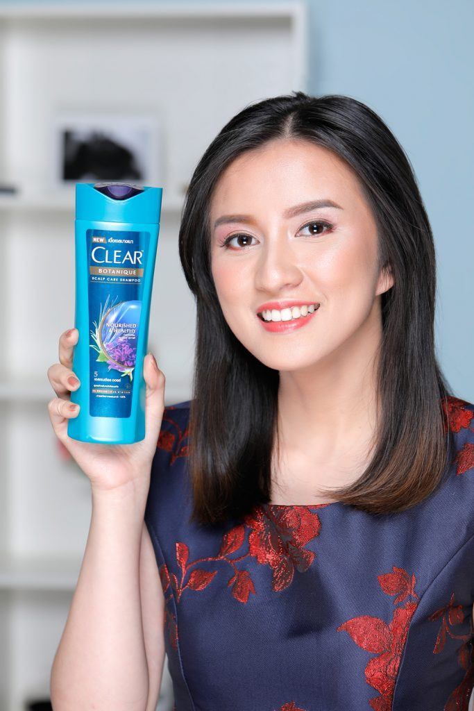 ผู้หญิงเอเชียผมยาวประบ่า ถือขวดแชมพูเคลียร์