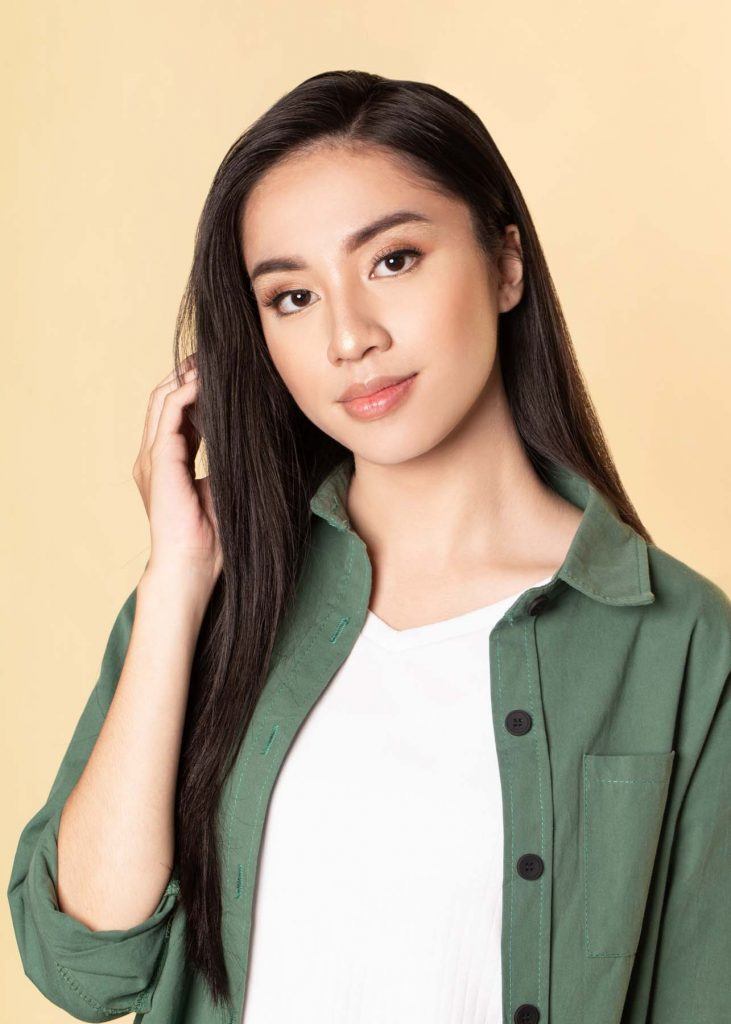 ผู้หญิงเอเชียผมยาว ใส่เสื้อเชิ้ตสีเขียว สาธิตวิธีทำผมทรงดังโงะ