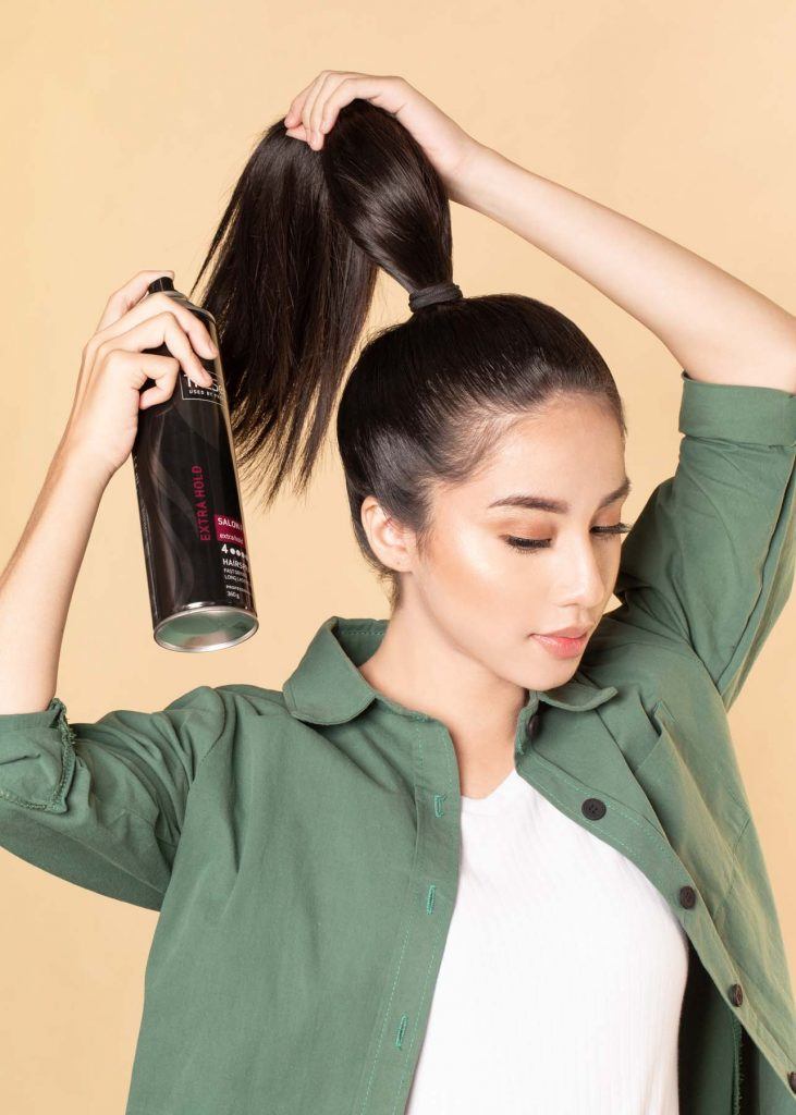 ผู้หญิงเอเชียผมยาว ใส่เสื้อเชิ้ตสีเขียว สาธิตวิธีทำผมทรงดังโงะ