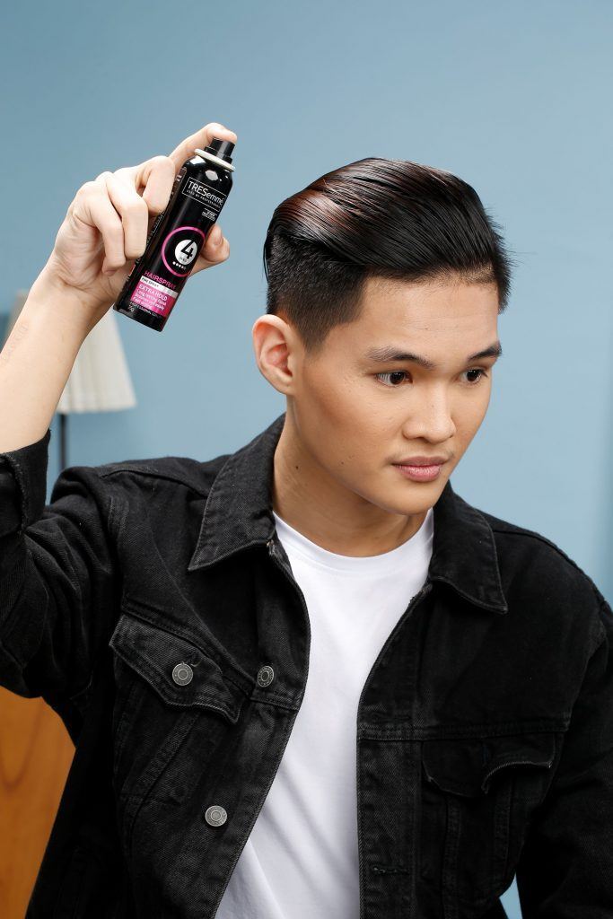ผู้ชายเอเชีย ไว้ผมสั้นสีดำ กำลังฉีดสเปรย์ เซ็ตผมทรงสลิคแบค