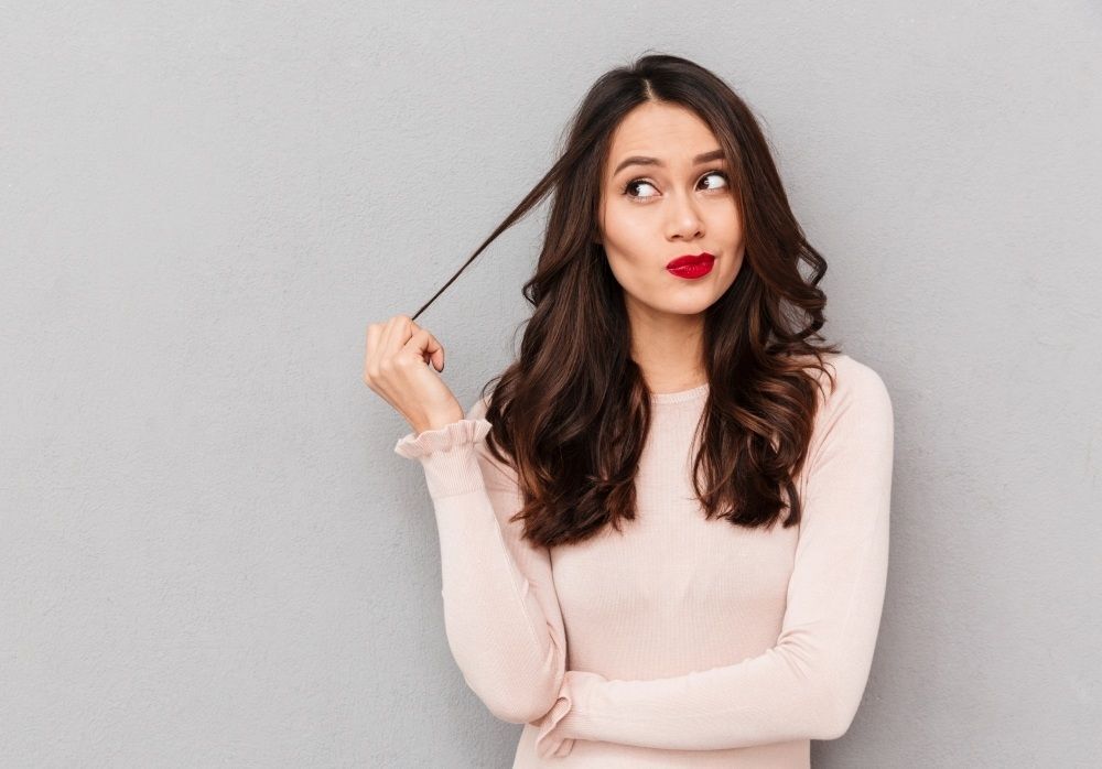 ผู้หญิงฝรั่ง ผมยาว กำลัง จับปลายผม ม้วนเกลียว