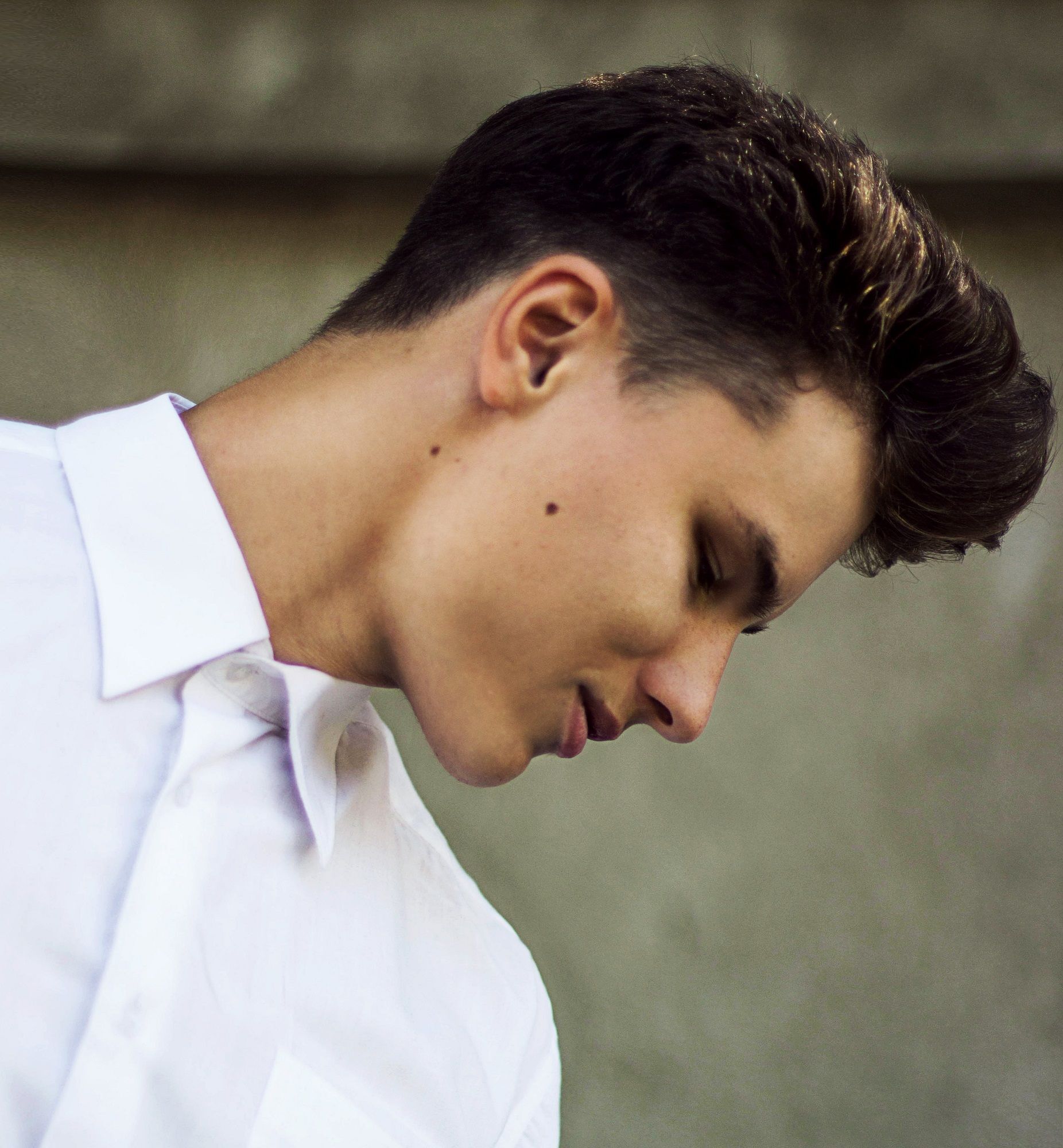 ผู้ชายฝรั่งไว้ ผมสั้นสีดำ หันข้าง โชว์ทรงผมไถข้าง หรือทรงผมเปิดข้าง ชื่อ ทรง ผม ชาย