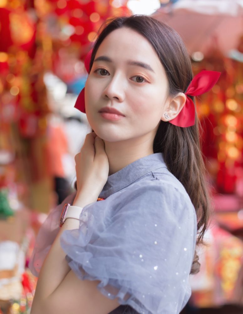 ผู้หญิงเอเชีย ไว้ผมยาว สีน้ำตาลแดง ปล่อยผมตรงและผูกริบบิ้น สำหรับเทศกาลตรุษจีน