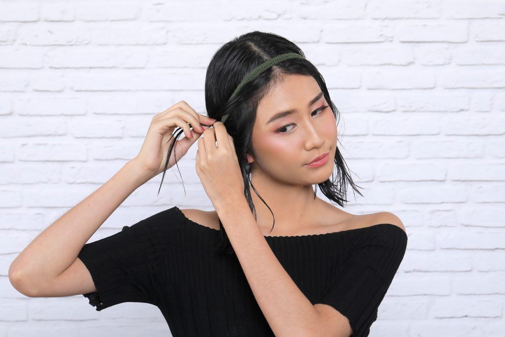 ผู้หญิงเอเชียผมสั้นกำลังสวมผมเฮดแบนด์ สาธิต วิธีเกล้าผมสั้น