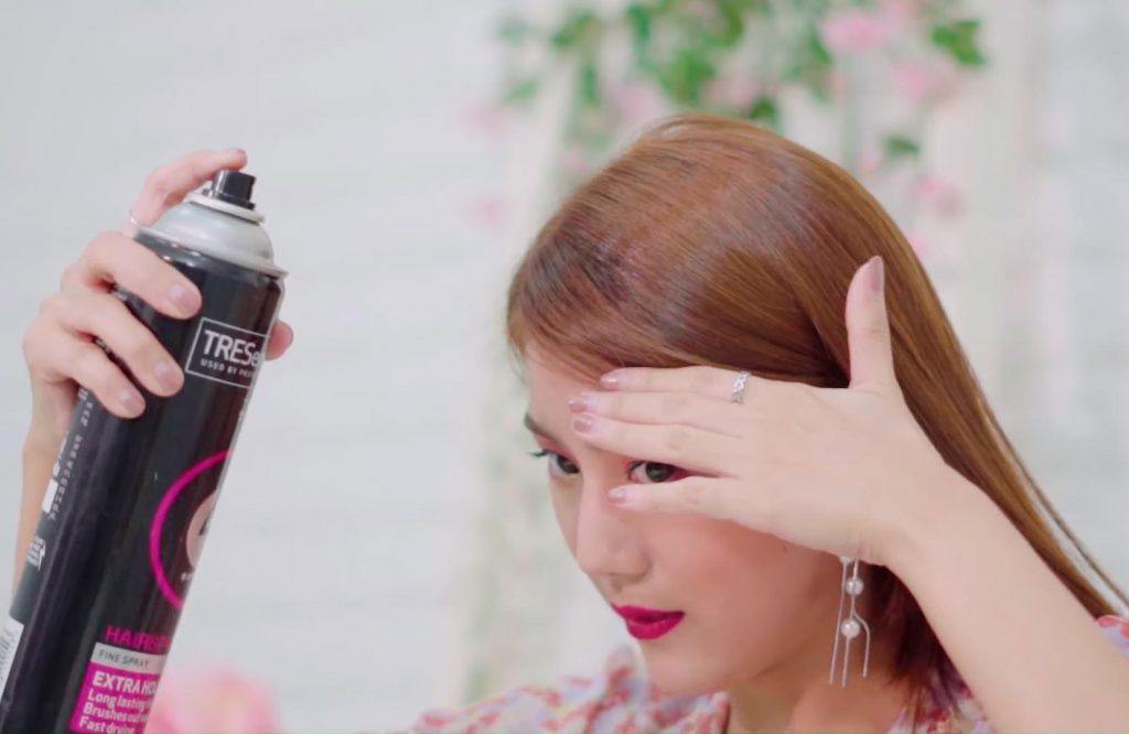ผู้หญิงเอเชีย ผมยาวสีน้ำตาล กำลังฉีดสเปรย์บนผม ทำทรงผม Sunmi Lalalay
