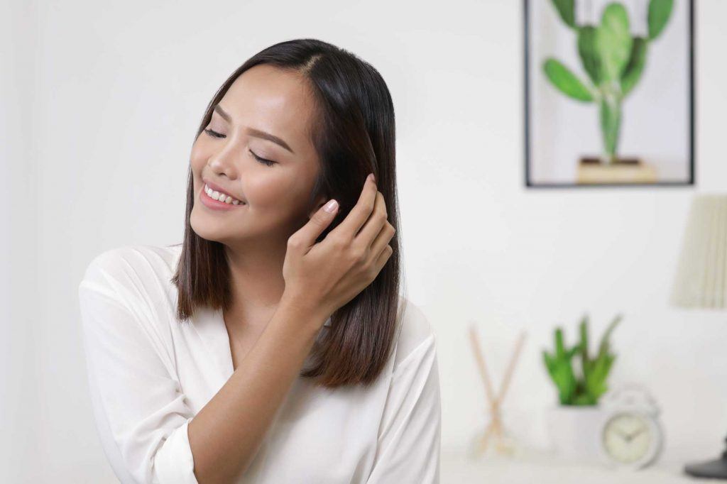 ผู้หญิงเอเชียผมยาวประบ่าสีดำ กำลังจับผม