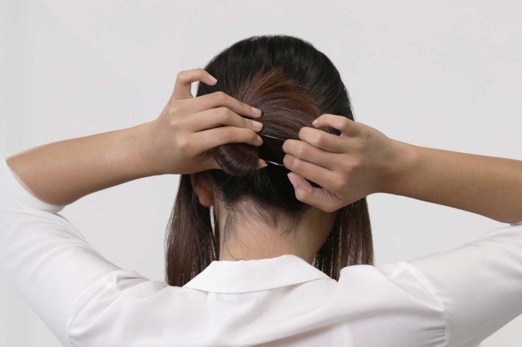 ผู้หญิงเอเชียผมยาวประบ่าสีดำ กำลังมัดผม