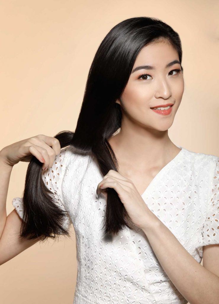 ผู้หญิงเอเชียผมยาวสีดำ กำลังผูกผม