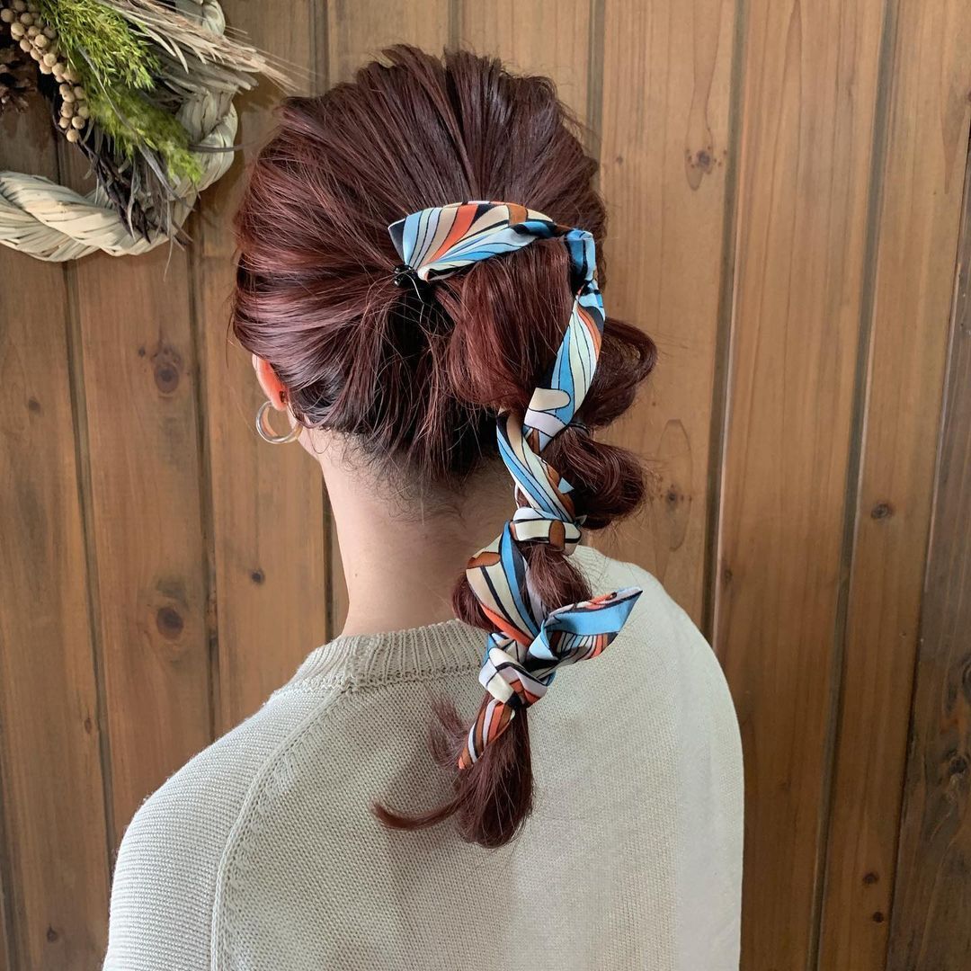 ผู้หญิงเอเชียหันหลัง ไว้ผมยาวมัดหางม้า ตกแต้งด้วยผ้าคลุมผม