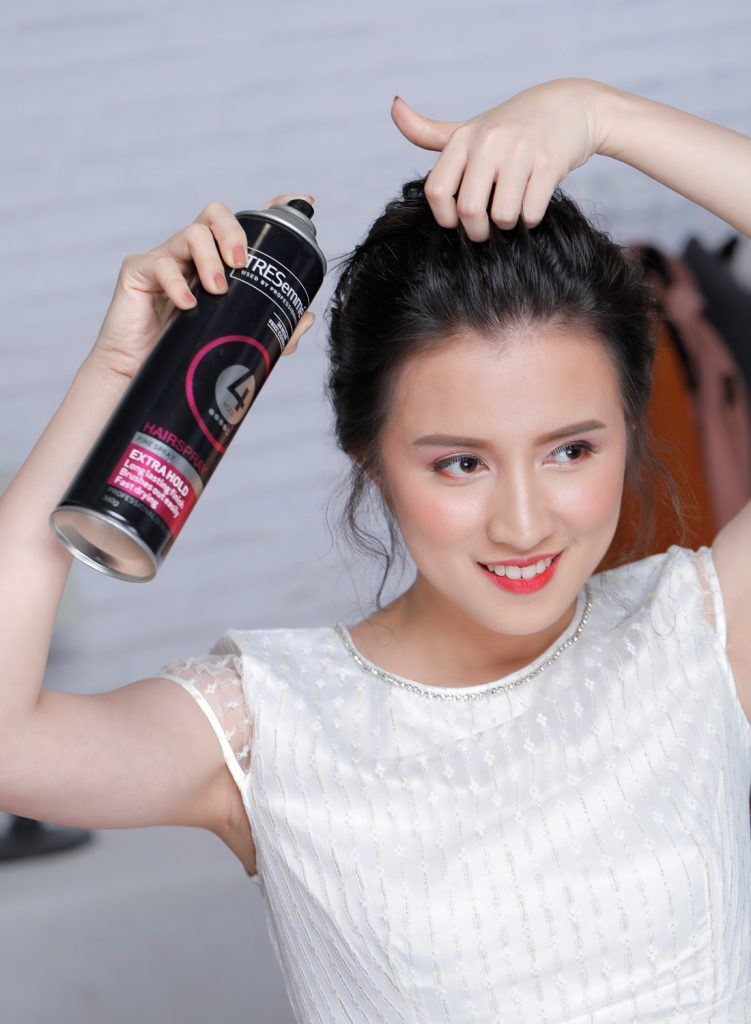 ผู้หญิงเอเชียผมหยักศกยาวประบ่า เกล้าผมมวยต่ำ