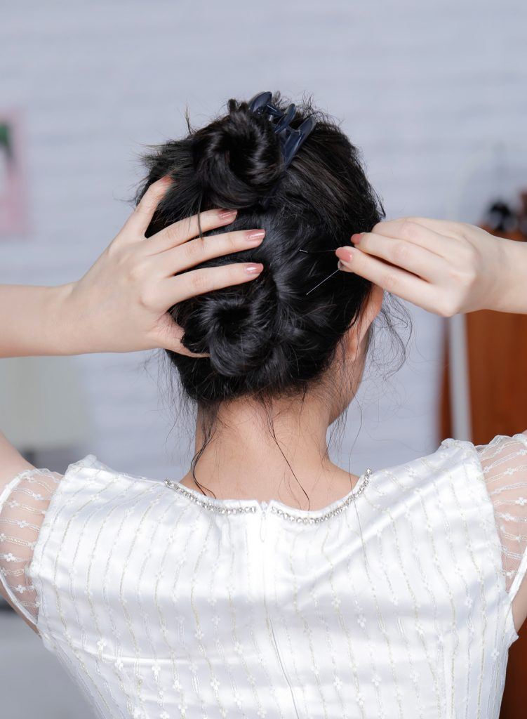 ผู้หญิงเอเชียผมหยักศกยาวประบ่า เกล้าผมมวยต่ำ