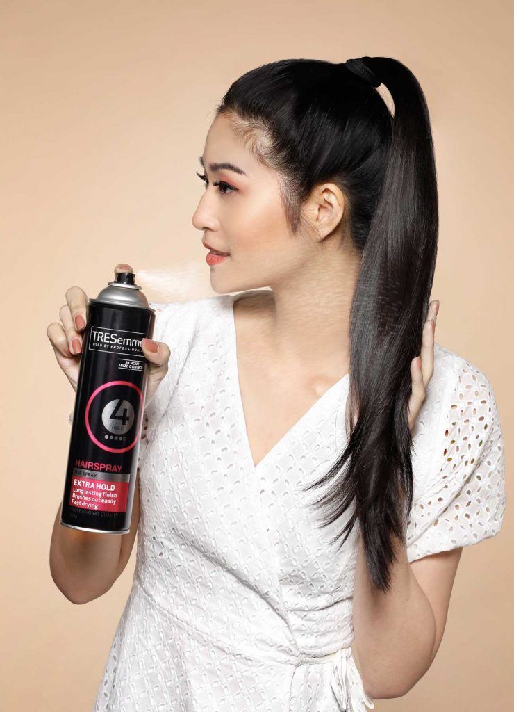 ผู้หญิงเอเชียผมยาวสีดำ กำลังฉีดสเปรย์