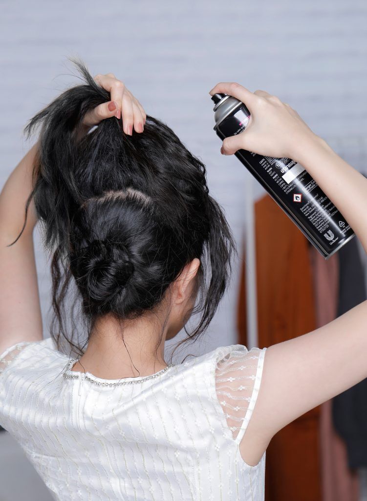 ผู้หญิงเอเชียผมหยักศกยาวประบ่า เกล้าผมมวยต่ำ