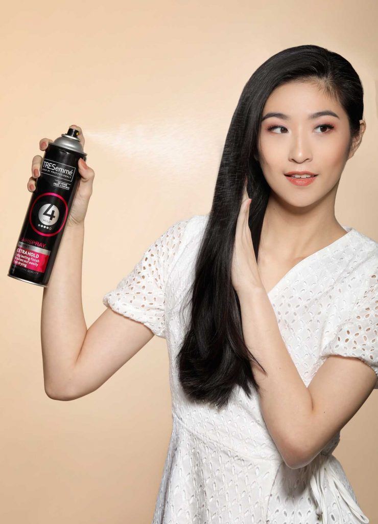 ผู้หญิงเอเชียผมยาวสีดำ กำลังฉีดสเปรย์