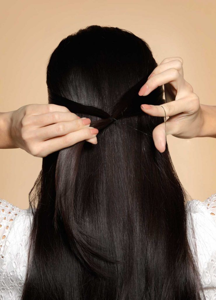 ผู้หญิงเอเชียผมยาวสีดำ กำลังมัดผมครึ่งหัว