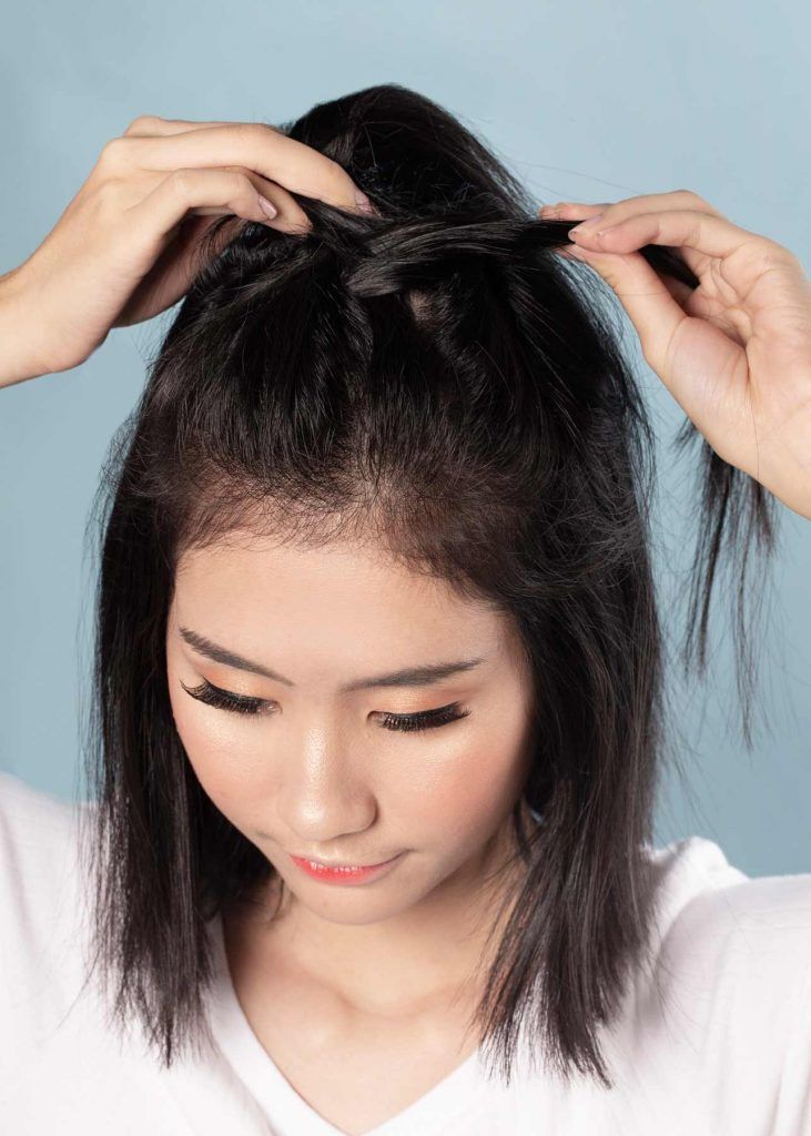 ผู้หญิงเอเชียผมสั้น ใส่เสื้อยืดสีขาว สาธิต ถักเปียนูนผมสั้น